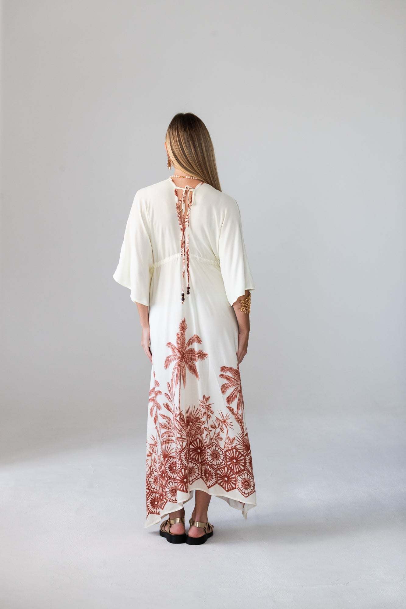 Georgia cream palm print kaftan, back view with model looking away