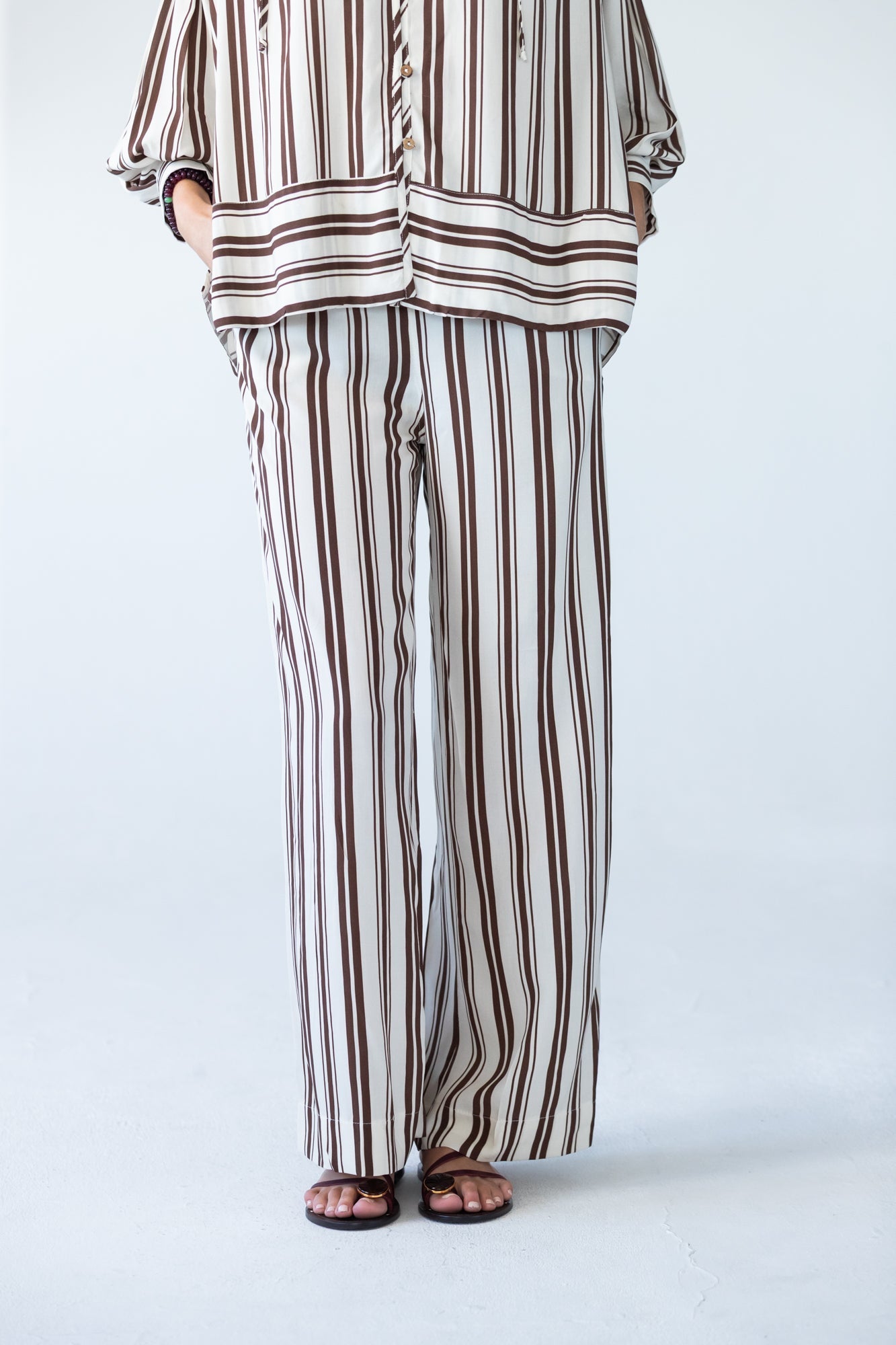 Sydney chocolate stripe wide leg pants, close up back view with hand in pocket