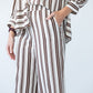 Sydney chocolate stripe wide leg pants, close up of waistband with hand in pocket