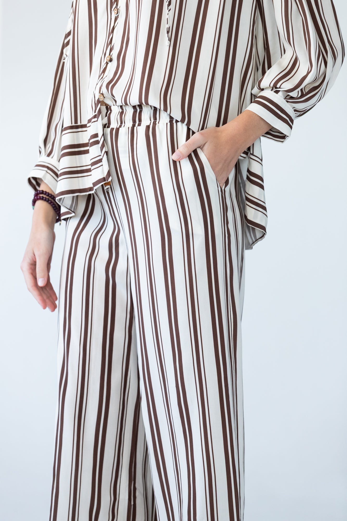 Sydney chocolate stripe wide leg pants, close up of waistband with hand in pocket