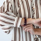 Blake chocolate stripe shirt, close up of cuff with hand adjusting sleeve