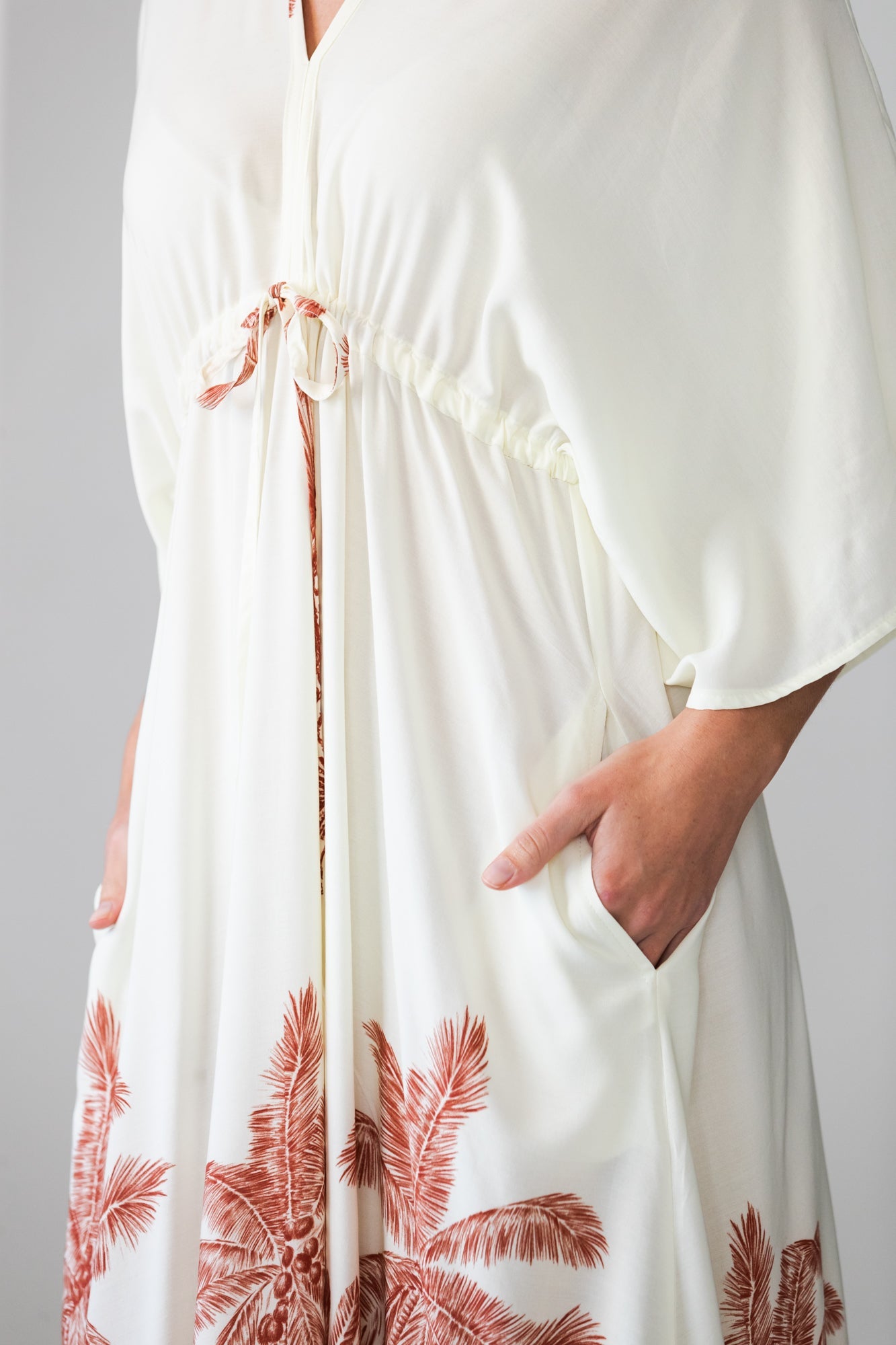 Georgia cream palm print kaftan, close up of pocket with hand inside