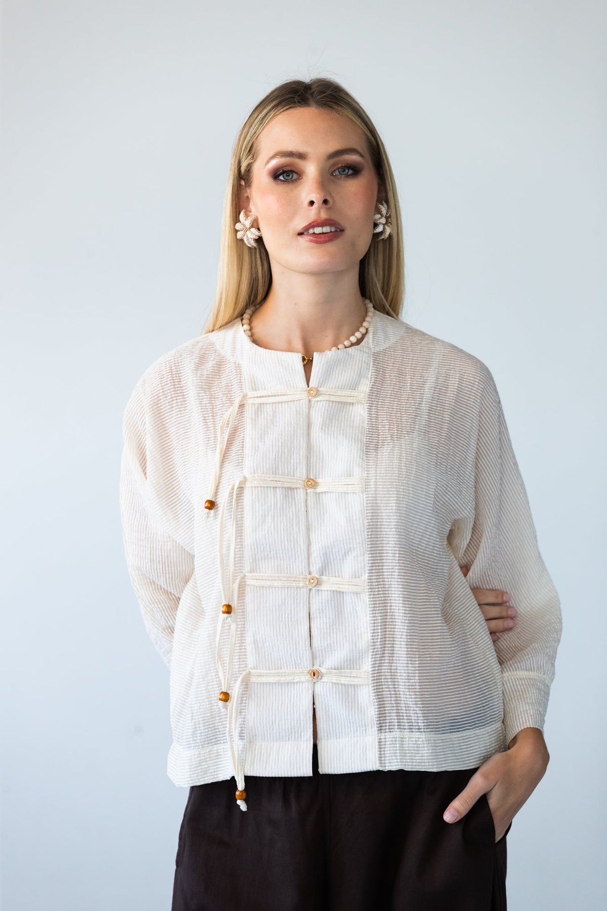 Amelia milk relaxed shirt, front view close up styled with black pants