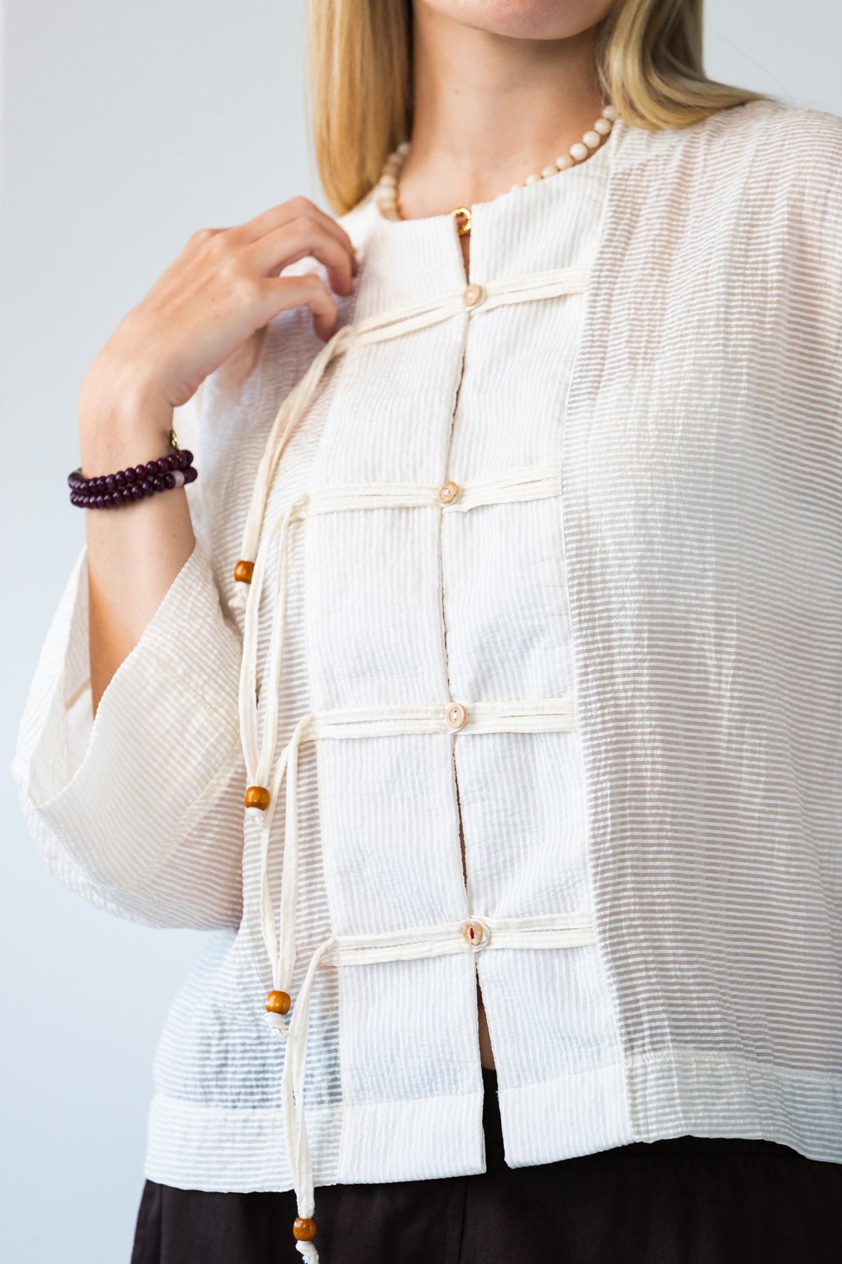 Amelia milk relaxed shirt, close up of button stand and toggle closures