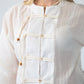 Amelia milk relaxed shirt, close up of neckline and toggle closures, smiling