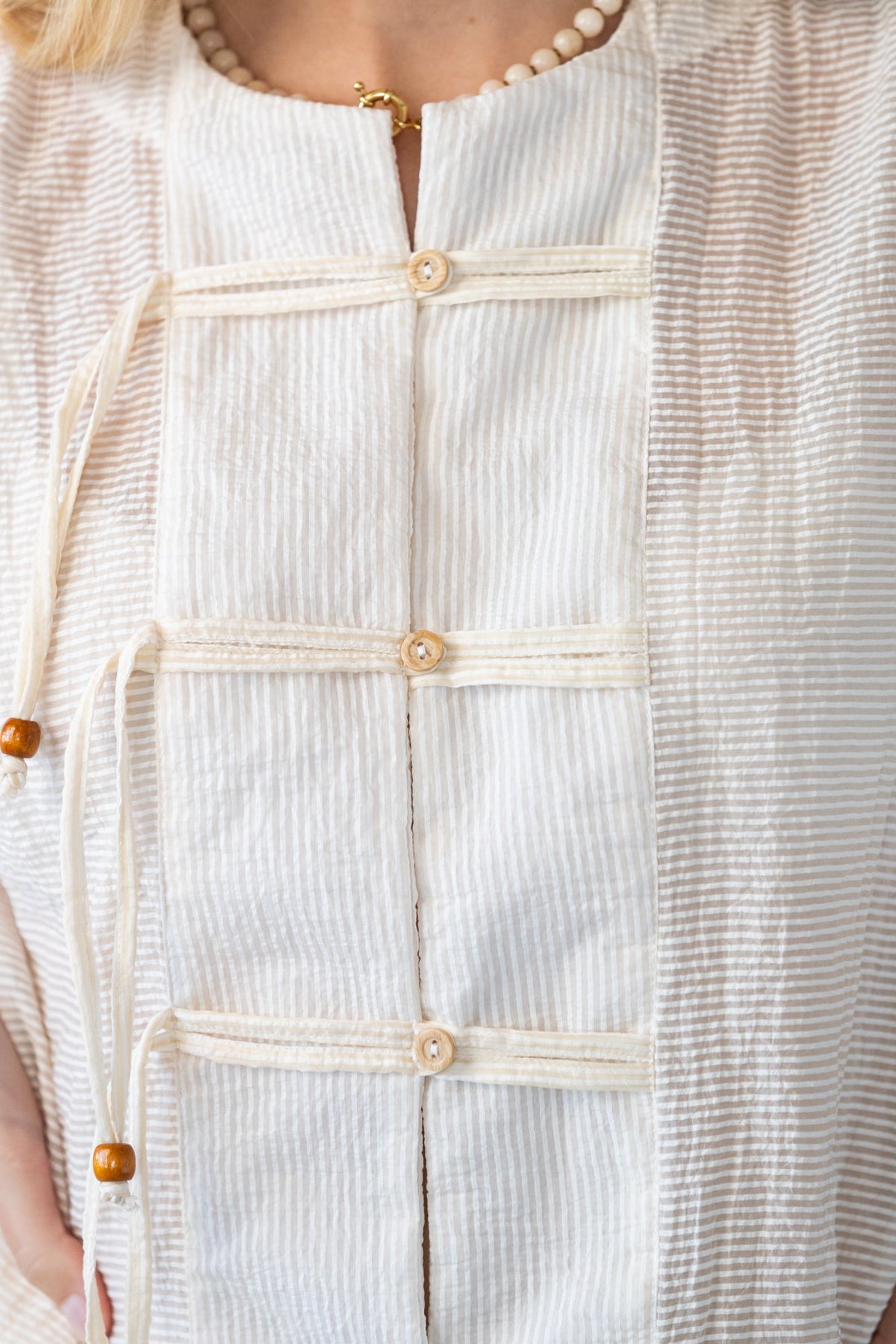 Amelia milk relaxed shirt, close up of neckline and toggle closures