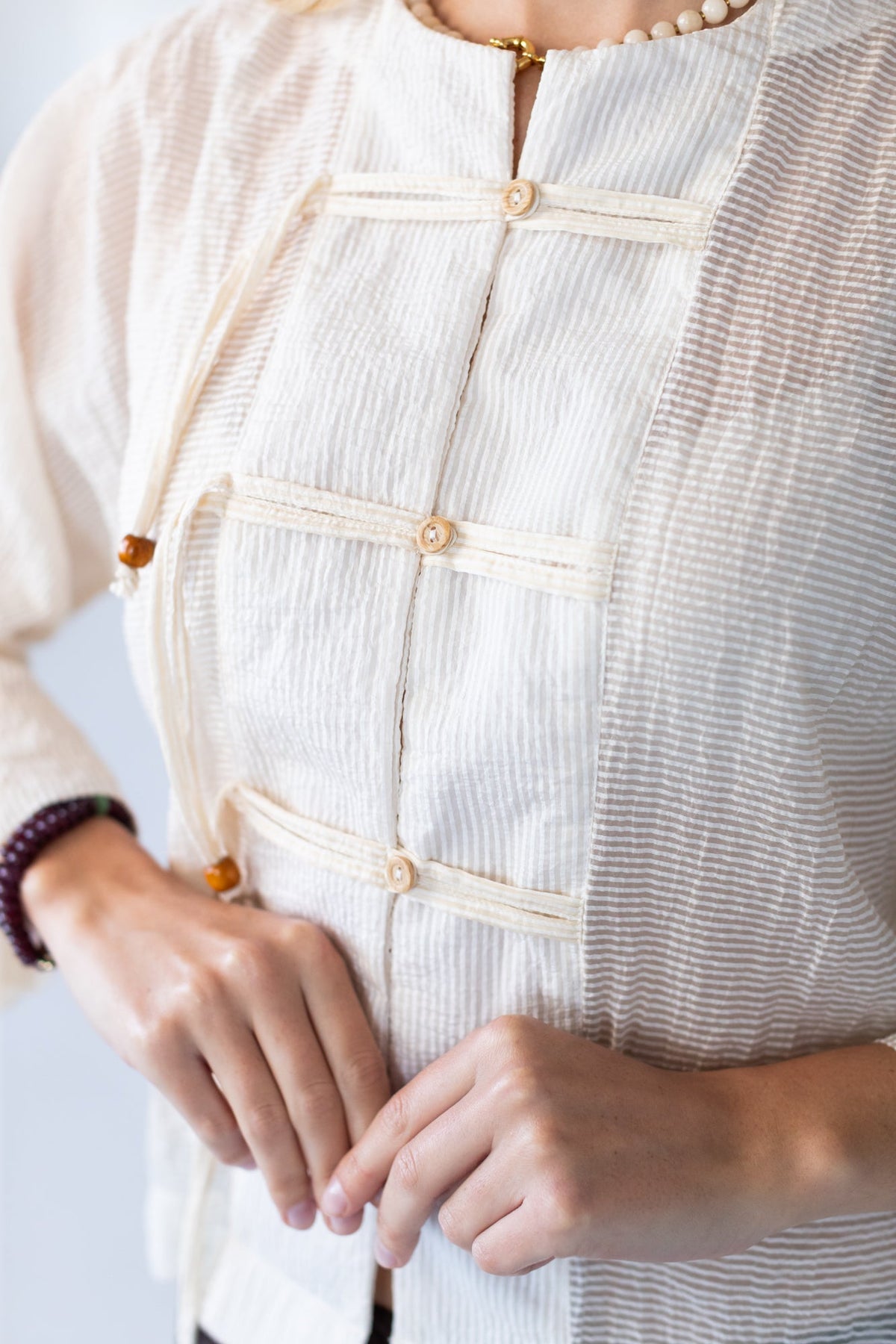Amelia milk relaxed shirt, close up detail of button stand and toggle closures