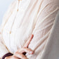 Amelia milk relaxed shirt, close up of batwing sleeve with hand adjusting collar