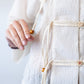 Amelia milk relaxed shirt, close up of wooden bead tassel detail held in hand