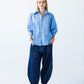Claire blue and white stripe shirt, front view styled with balloon pants and sneakers