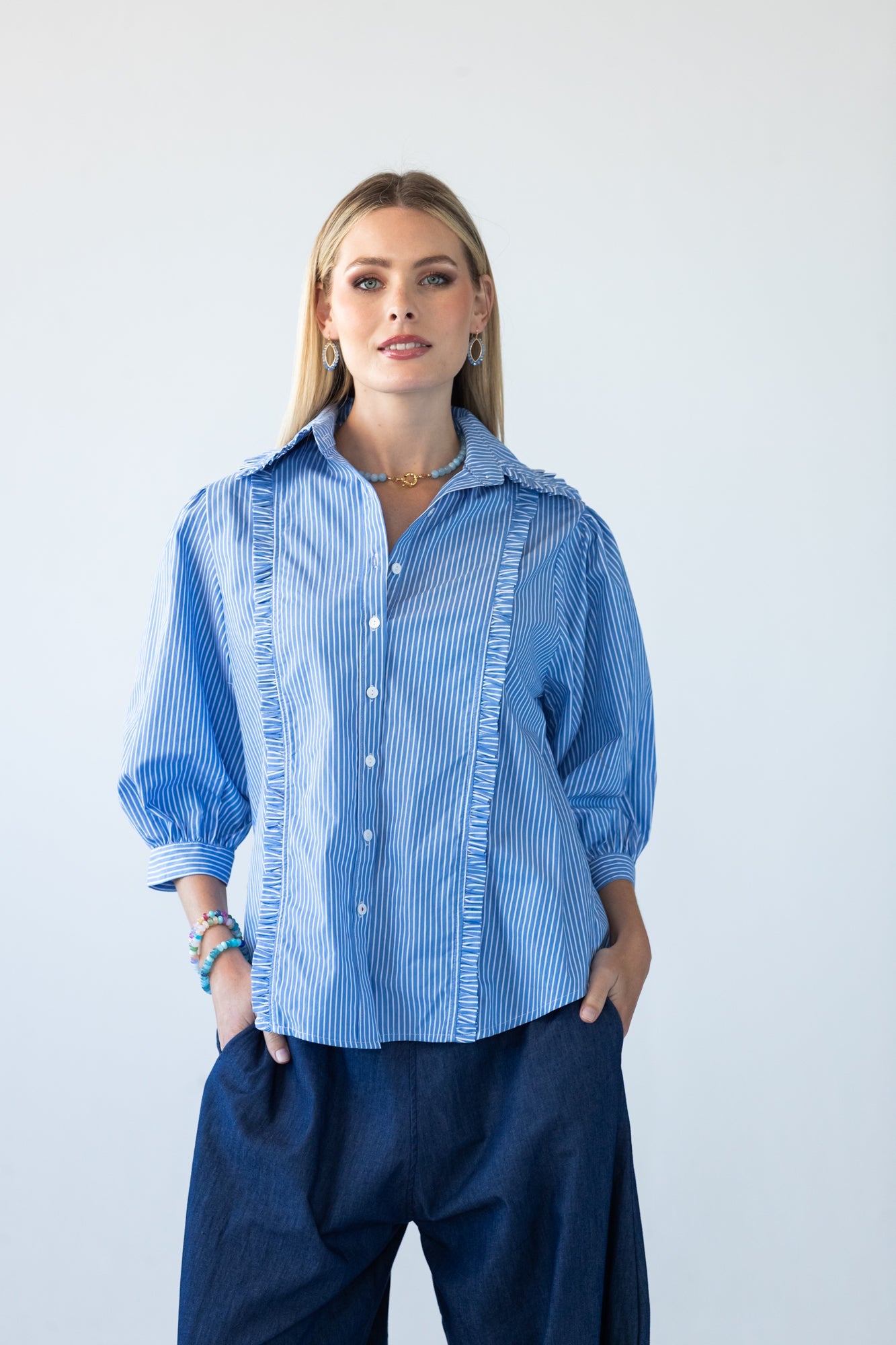 Claire blue and white stripe shirt, front view styled with denim wide-leg trousers