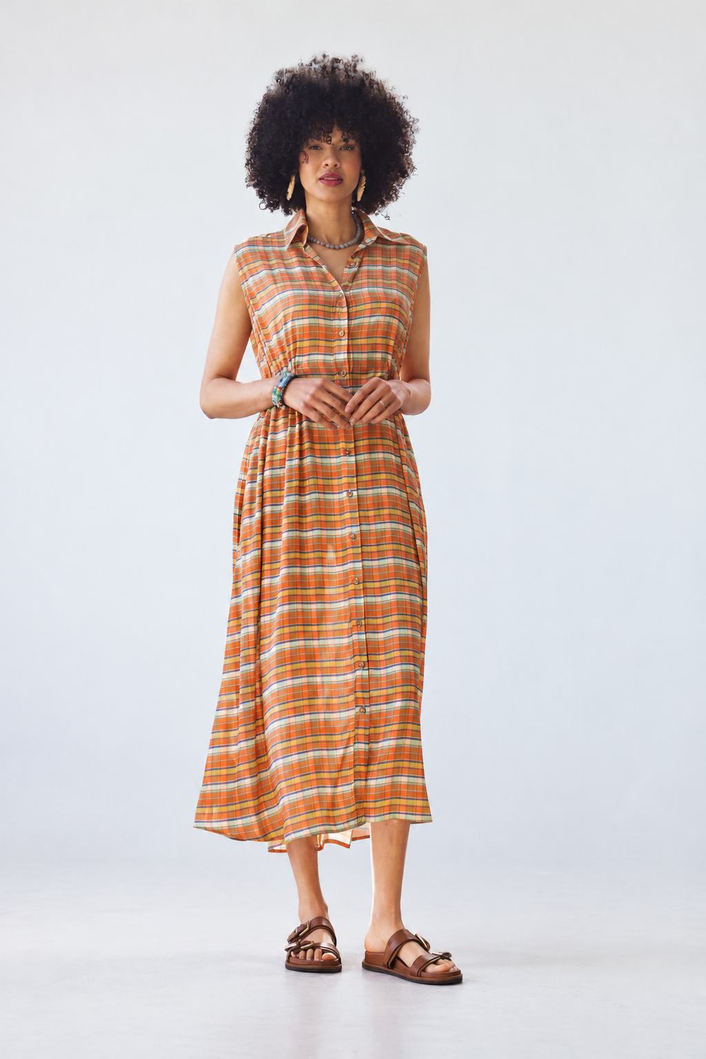 Sutton sleeveless shirt-dress in orange check, full-length front view with hands clasped